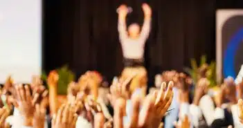 people raising hands with bokeh lights