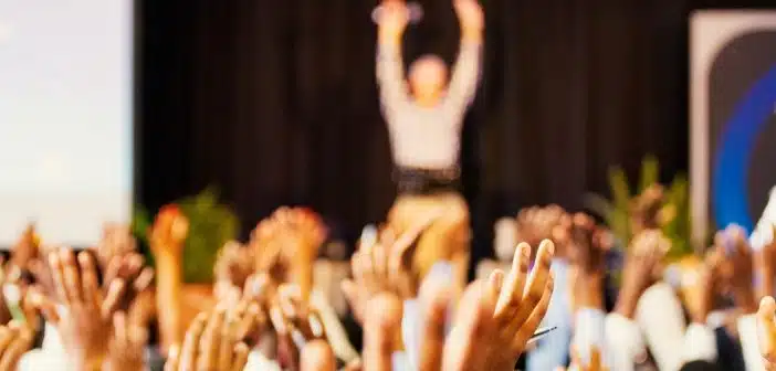 people raising hands with bokeh lights